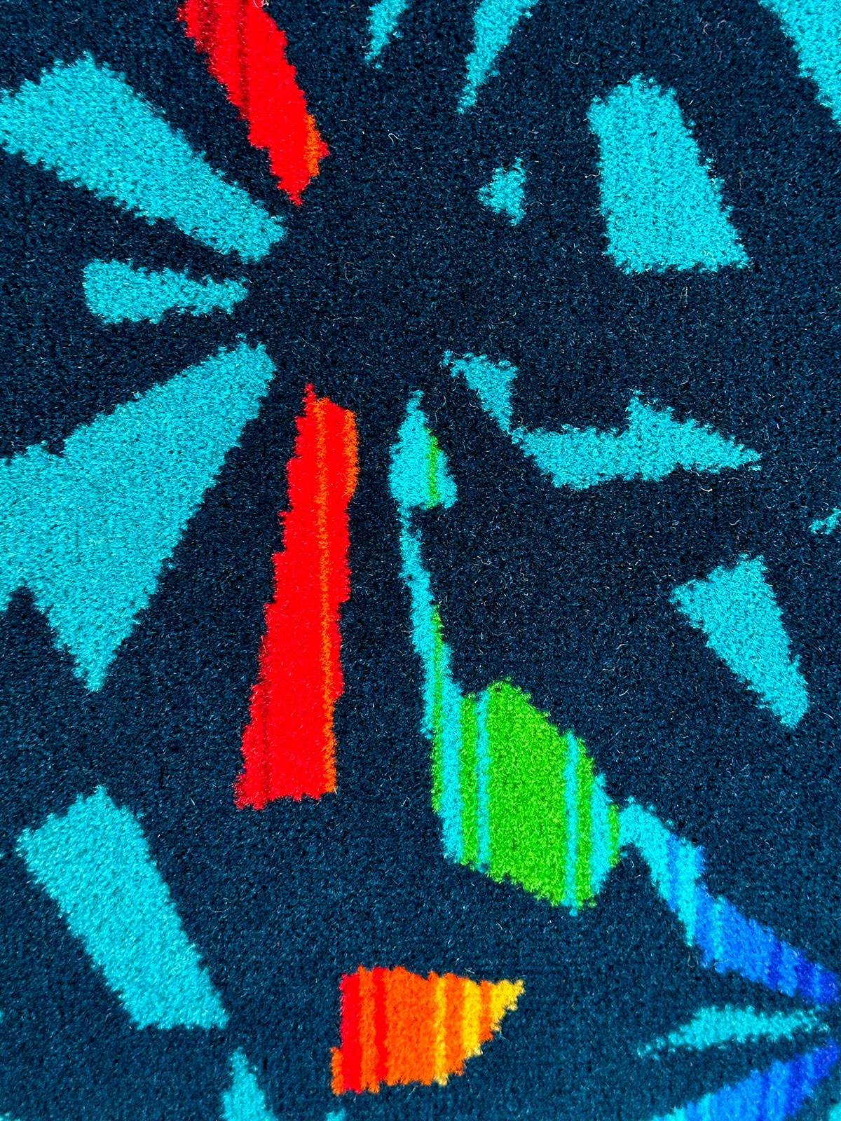 Navy blue moquette cushion with multicoloured fragments