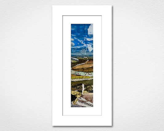 Framed artwork of a landscape with a mountain and text on a white wall