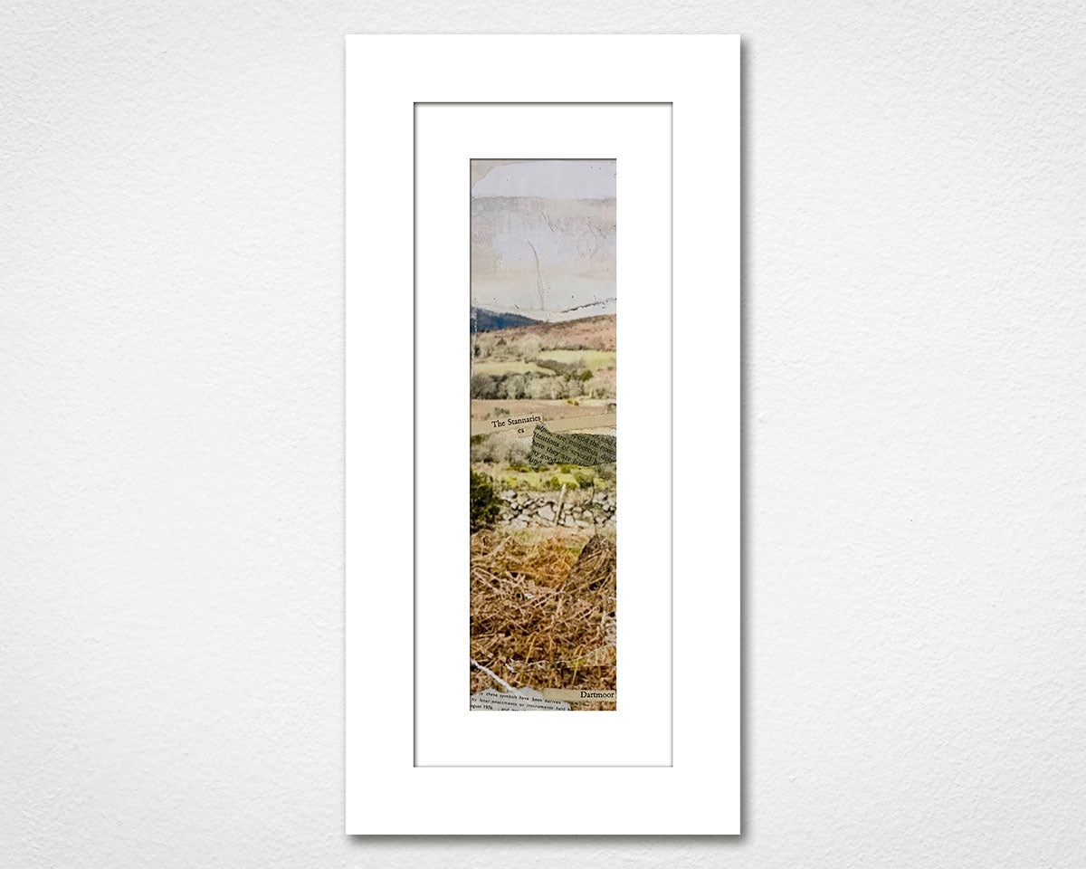 Framed landscape print of a field with trees on a white wall