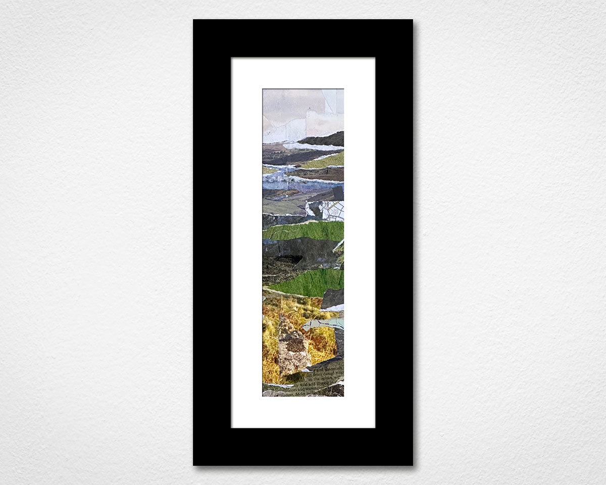 Framed artwork with a landscape scene on a white wall