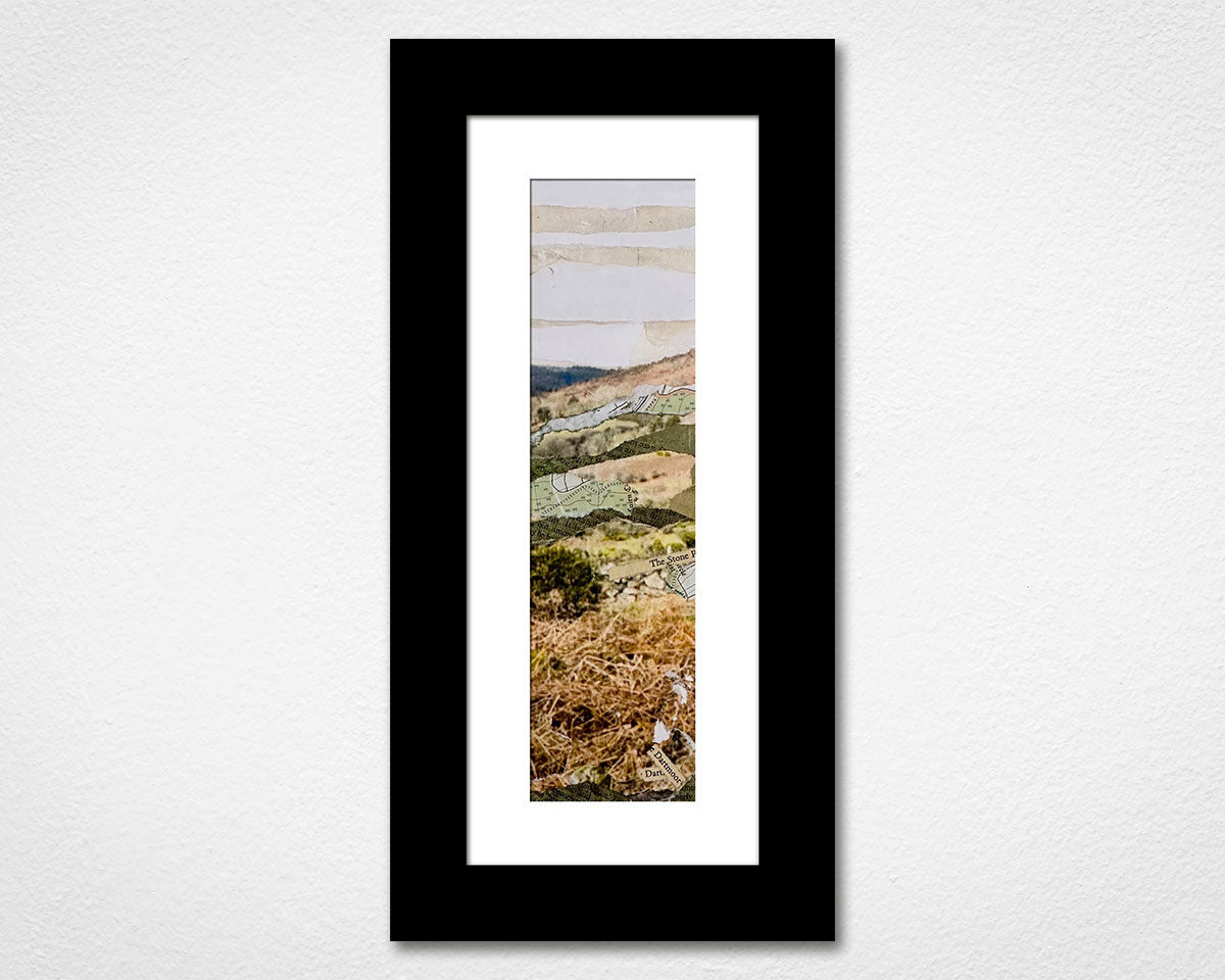 Framed landscape print of a scenic view with a black frame on a white wall.
